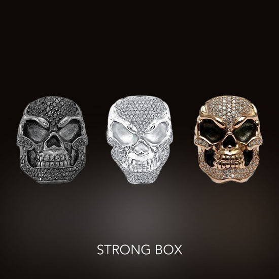 Three skull rings with diamonds and Strong Box text